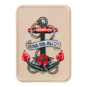 Puede incluir: Un parche de tela beige con un diseño de tatuaje de ancla colorido. El ancla es verde, roja y marrón con una cuerda envuelta alrededor. Una pancarta con el texto "Sink or Swim" está envuelta alrededor del ancla.