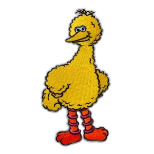Può includere: Toppa ricamata raffigurante un uccello giallo dei cartoni animati con occhi blu, becco arancione e piedi rossi. L'uccello ha un aspetto soffice ed è in piedi. La toppa è delineata da un bordo nero.