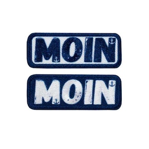 Könnte beinhalten: Zwei blaue und weiße gestickte Patches mit dem Wort "MOIN" in weißen Buchstaben. Die Patches haben ein nautisches Thema mit kleinen Anker-Symbolen.