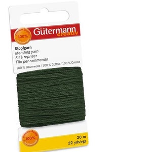 Puede incluir: Una bobina de hilo de zurcir verde oscuro, etiquetada "Gutermann Creativ Stopfgarn" y "100% Baumwolle/100% Cotton/100% Cotone". La bobina tiene 20 metros (22 yardas) de largo.