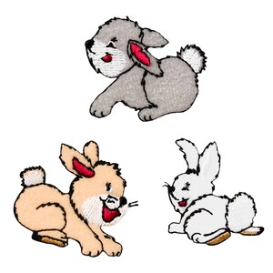 Könnte beinhalten: Drei gestickte Bügelbilder mit Cartoon-Hasen in verschiedenen Farben. Der erste Hase ist grau mit roten Ohren, der zweite ist hellbraun mit weißen Akzenten und der dritte ist weiß mit schwarzen Augen.