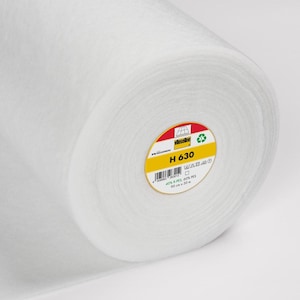 May include: A white roll of interfacing fabric with a yellow and red label that says "H 630" and includes care instructions. The label also says "40% B-PEL 60% PES 90 cm = 30"