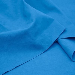 Könnte beinhalten: Nahaufnahme eines leuchtend blauen Stoffes mit glatter Textur. Der Stoff ist in der Mitte gefaltet und erzeugt einen weichen, fließenden Fall.