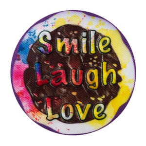 Può includere: Un cerotto rotondo con bordo viola, sfondo marrone e testo colorato che dice "Smile Laugh Love".