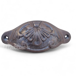 May include: A dark brown cast iron drawer pull with a decorative floral design.