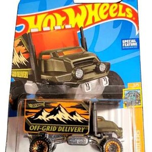Puede incluir: Un camión de juguete Hot Wheels Baja Hauler en un paquete azul y naranja. El camión es de color verde oliva con detalles en negro y naranja, y presenta el texto "OFF-GRID DELIVERY". El paquete tiene el logotipo de Hot Wheels.