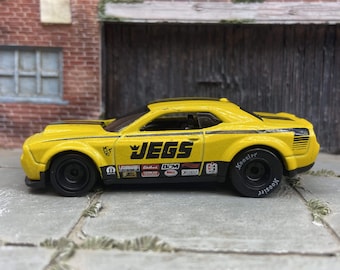 Hot Wheels 2018 Dodge Challenger SRT Demon en Jegs amarillo y negro con ruedas de carrera negras y neumáticos de goma Hoosier