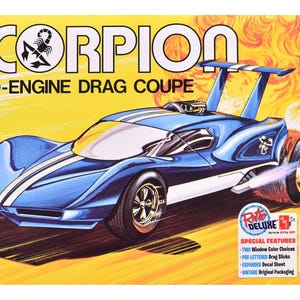 May include: A model kit box for the Scorpion Mid-Engine Drag Coupe featuring a blue race car with white stripes, a large rear wing, and a scorpion logo. The background shows yellow and orange flames. Text includes SCORPION, Retro Deluxe, and amt.