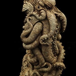 May include: A detailed ceramic sculpture of an octopus with a textured surface and intricate details. The sculpture is painted in shades of brown and beige.