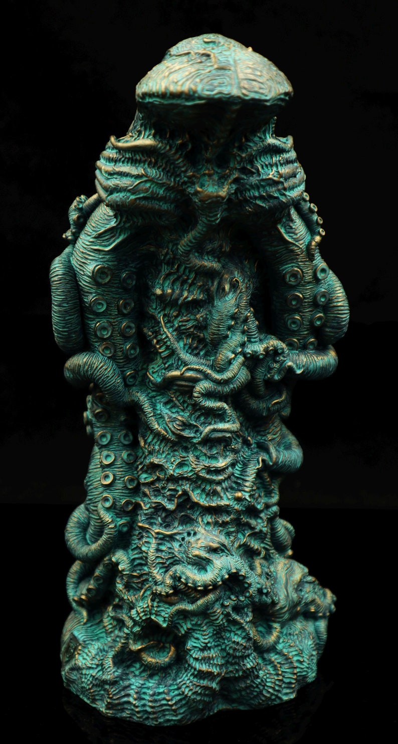 May include: A teal green and gold colored statue of a tentacled creature with a large head. The creature is depicted with many tentacles and a textured surface.