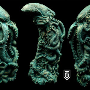 May include: A detailed, green and gold, sculpted octopus figurine. The octopus is curled up with its tentacles wrapped around itself. The figurine is made of a textured material and has a realistic appearance.