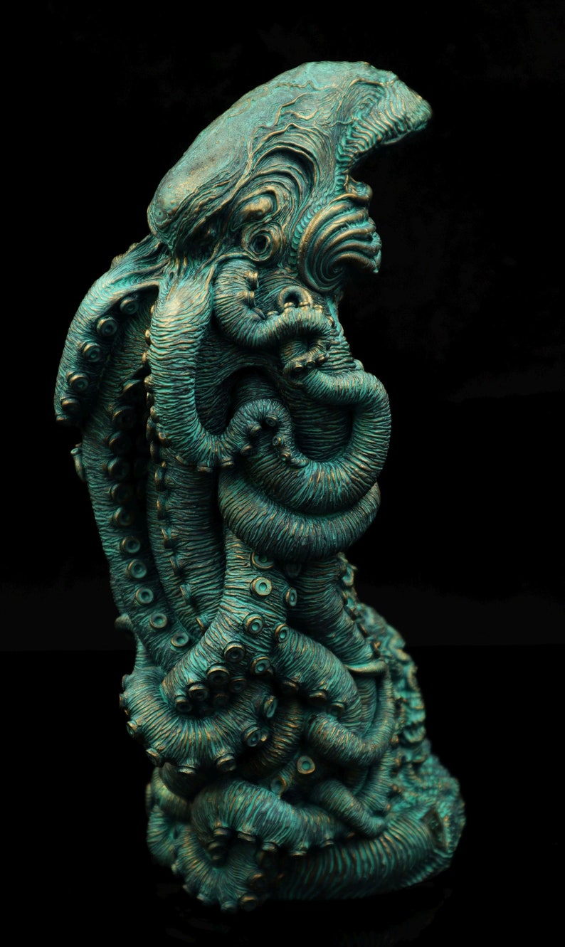 May include: A teal green, detailed, sculpted octopus figurine with multiple tentacles. The octopus is curled in on itself, with its head and eyes visible.
