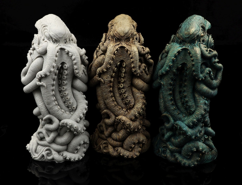May include: Three detailed octopus sculptures, each painted in a different color: white, brown, and blue-green. The sculptures are made of a textured material and have a realistic appearance.