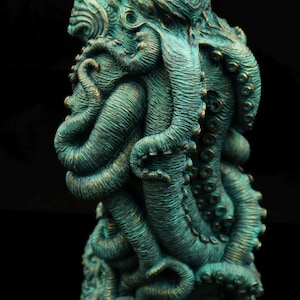 May include: A teal green, detailed sculpture of an octopus with its tentacles wrapped around itself. The sculpture is made of a textured material and has a realistic appearance.