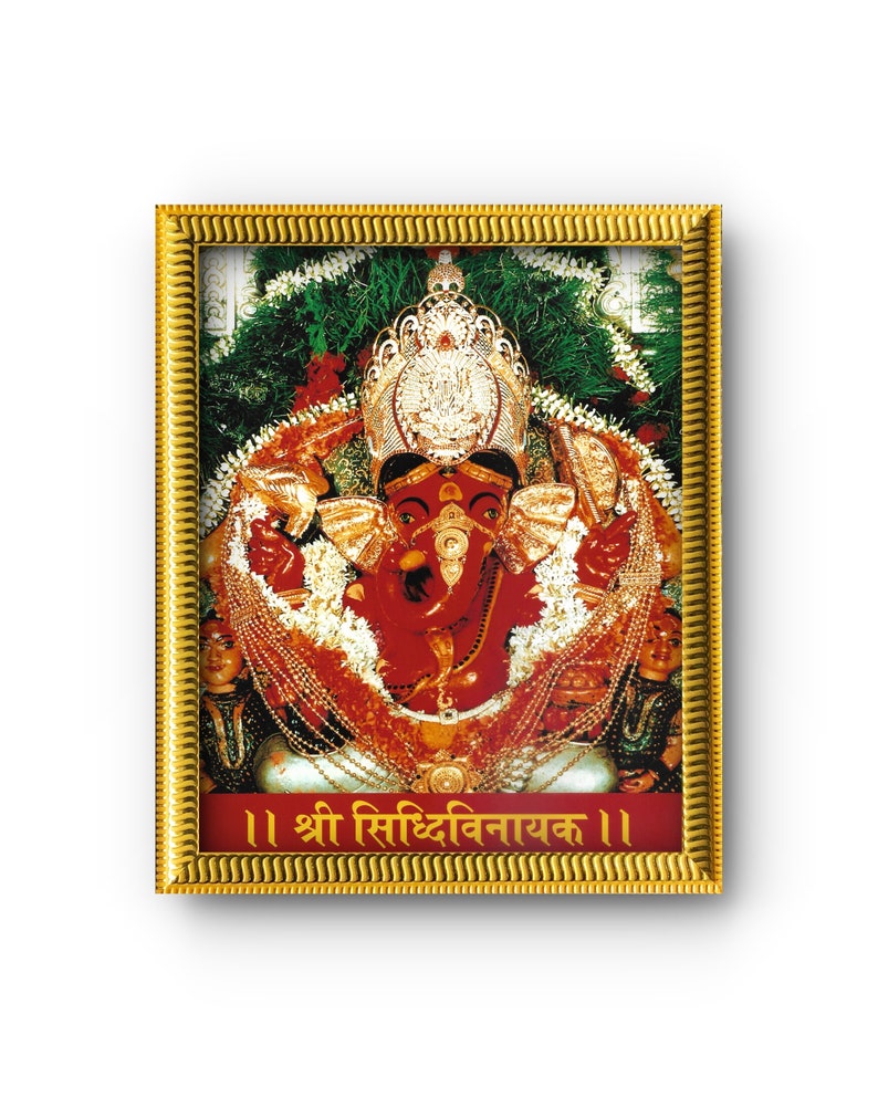 May include: A framed image of the Hindu deity Ganesha, depicted with a red complexion, adorned with gold jewelry and a crown. The image is set against a backdrop of green foliage and red flowers, with text in a foreign language at the bottom.