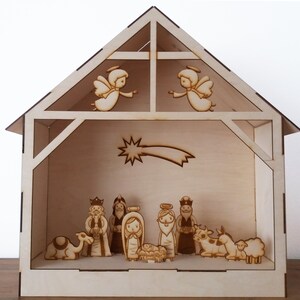 Könnte beinhalten: Eine hölzerne Weihnachtskrippe mit einem Stern und Engeln über den Figuren. Die Figuren umfassen Maria, Josef, das Jesuskind, einen Esel, eine Kuh und drei Könige.