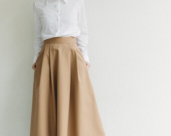 Sand-colored cotton twill full skirt with side pockets, elastic on the back of the band and zip closure