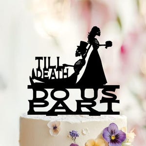 May include: A black cake topper featuring silhouettes of a skeleton bride and groom. The groom wears a top hat and the bride holds a bouquet. The text TILL DEATH is integrated into the design, with DO US PART displayed in bold letters below.