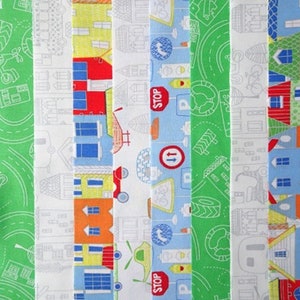 May include: A set of 8 fabric strips with a city theme. The strips feature a variety of designs, including houses, cars, stop signs, and traffic lights. The fabric is white with blue, green, red, and orange accents.
