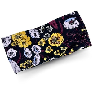 May include: A black headband with a floral pattern featuring yellow, white, and pink flowers on a dark background.