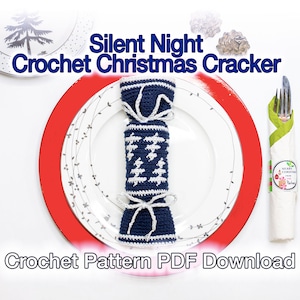 Puede incluir: Un cracker de Navidad tejido a crochet en azul y blanco con un patrón de árbol blanco. El cracker está atado con una cinta blanca y está sentado en un plato blanco con un borde rojo. El texto "Silent Night Crochet Christmas Cracker" está por encima de la imagen. El texto "Crochet Pattern PDF Download" está debajo de la imagen.