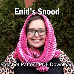 May include: A close-up of a person wearing a black crocheted cowl with a fur trim. The cowl is pulled up over the person's head, and they are wearing glasses.