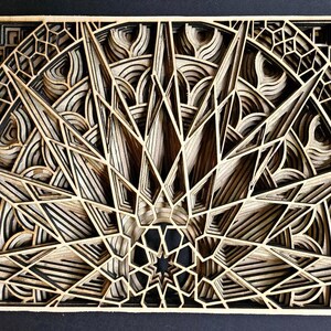 May include: A wooden wall art piece with a geometric design. The design is made up of multiple layers of wood, creating a 3D effect. The piece is painted in shades of brown and black.