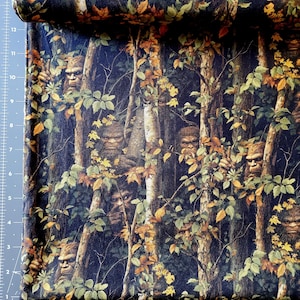 May include: Fabric with a forest scene featuring Bigfoot figures among trees and foliage. The fabric has a dark blue background with brown, green, and yellow leaves. The Bigfoot figures are brown and have a hairy appearance.