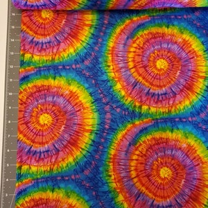 Pode incluir: Tecido tie-dye multicolor com um padr&atilde;o de redemoinho de rosa, vermelho, amarelo, laranja, verde e azul.