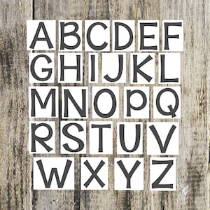 May include: White squares with black letters spelling out the alphabet, A through Z, on a wood background.