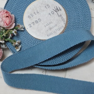May include: A roll of blue grosgrain ribbon with a white label that reads "6514 .2785 15 10 Yds coton viscose Made in France".