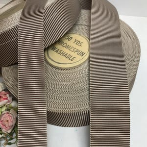 May include: A roll of brown and white striped ribbon with a label that reads "50 YDS. CHROMESPUN WASHABLE".
