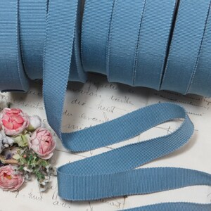 May include: A roll of light blue grosgrain ribbon. The ribbon is 1.2 cm wide and has a subtle ribbed texture.