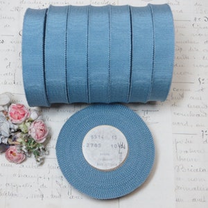 May include: A roll of 10 yards of blue grosgrain ribbon. The ribbon is 1/2 inch wide and is made of cotton and viscose. The label on the ribbon reads "6514 15 .2785 10 Yds Cotton Viscose Made in France".