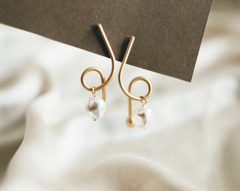 Elegant asymmetrical gold earrings with natural pearls