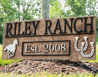 May include: Wooden sign with the text "RILEY RANCH Est. 2008" in black and silver lettering. The sign also features a silhouette of a horse and two silver horseshoes.