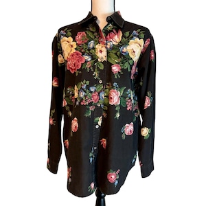 May include: Black button-down shirt with a vibrant floral pattern. The shirt has a classic collar and long sleeves. The floral design includes pink, yellow, and blue roses with green leaves.