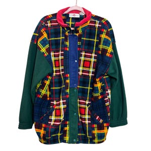 May include: A vintage fleece jacket with a vibrant plaid pattern in red, yellow, and blue. The jacket features green sleeves and trim, a red collar, and a blue center panel. It has a button-up front and two pockets.