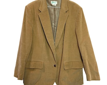 May include: A tan corduroy blazer featuring a notched lapel, a single front button closure, and two flap pockets at the waist. The interior is lined with a matching tan fabric and includes a white brand label at the neck area.