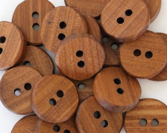 May include: A pile of 15 brown wooden buttons with two holes each.