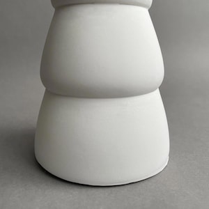 Puede incluir: Pedestal de cer&aacute;mica blanca con un dise&ntilde;o redondeado y escalonado. El pedestal tiene un acabado liso y mate.