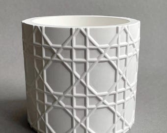 Maceta de color blanco roto, hecha a mano en estilo minimalista con un patrón gráfico, soporte para pinceles o bolígrafos.