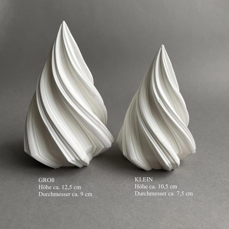 Może przedstawiać: Dwie białe ceramiczne rzeźby w kształcie spirali. Większa rzeźba jest oznaczona jako "GROB" i ma 12,5 cm wysokości i 9 cm średnicy. Mniejsza rzeźba jest oznaczona jako "KLEIN" i ma 10,5 cm wysokości i 7,5 cm średnicy.