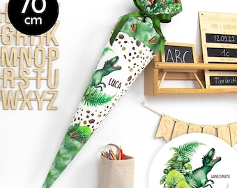 Può includere: Un cono scolastico verde e marrone con un design di dinosauro. Il cono è alto 70 cm e ha uno sfondo bianco con macchie marroni. Il dinosauro è verde e ha il nome "LUCA" scritto su di esso. Il cono è decorato con foglie verdi e un fiocco verde. Il cono è seduto su uno scaffale di legno con un cartello che dice "ABC".