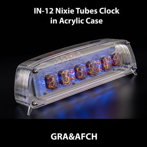 Könnte beinhalten: Ein transparentes Acrylgehäuse mit einer Nixie-Röhrenuhr im Inneren. Die Uhr zeigt die Zeit 03:11:41 an. Die Uhr ist mit "NCT412 V1.0" beschriftet. Die Uhr steht auf einer schwarzen Oberfläche.