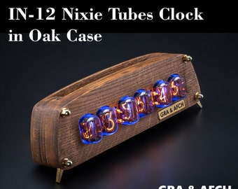May include: A wooden clock with a dark brown oak case and a display of glowing orange Nixie tubes. The clock is labeled "GRA & AFCH" and "IN-12 Nixie Tubes Clock in Oak Case".