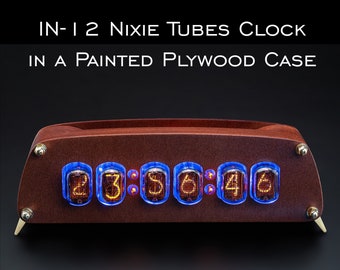 May include: A wooden clock with a dark brown finish and six Nixie tubes displaying the time 23:36:46. The clock is labeled "IN-12 Nixie Tubes Clock in a Painted Plywood Case" and "GRA & AFCH".