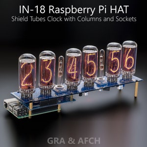 Puede incluir: Un reloj Raspberry Pi HAT con seis tubos Nixie que muestran la hora 23:45:56. El reloj está montado en una placa de circuito azul con separadores dorados. La placa tiene un Raspberry Pi conectado a ella.