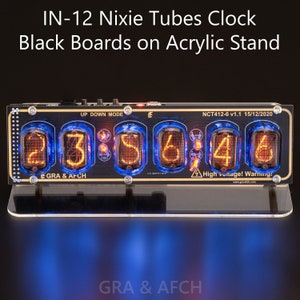 Puede incluir: Un reloj de tubos Nixie negro y dorado con un soporte de acrílico azul. El reloj muestra la hora 23:56:46. El reloj tiene una etiqueta que dice "NCT412-6 v1.1 15/12/2020".