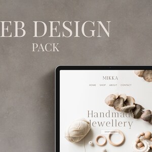 May include: A laptop screen displaying a website for Mikka Handmade Jewellery. The website features a white background with a light brown and white color scheme. The website text reads "Mikka Handmade Jewellery" and "Shop Now". The website also features a navigation bar with the following links: Home, Shop, About, Contact.